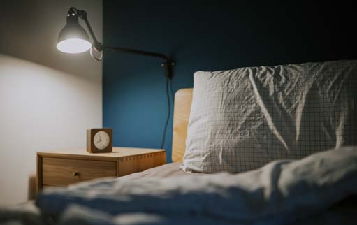 Image of a bedroom with a bedside light switched on